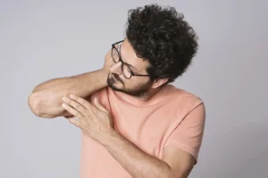 chico mirando el codo con psoriasis