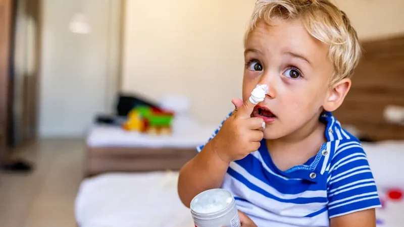 dermatitis atópica. niño con crem ahidratante