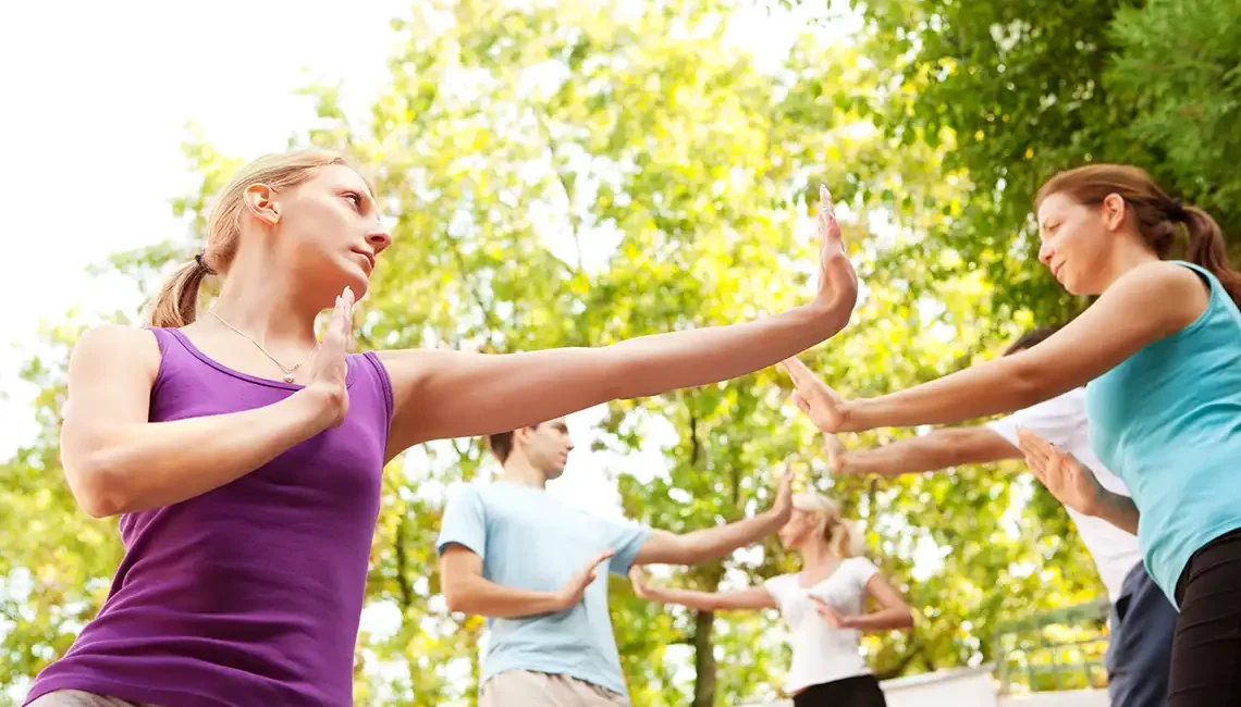 yoga y taichí. Gente practicando taichí en el parque