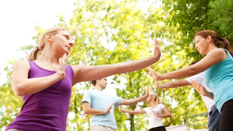 yoga y taichí. Gente practicando taichí en el parque