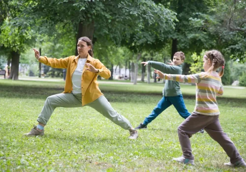 yoga y taichí. Mujer con niños practicando taichí